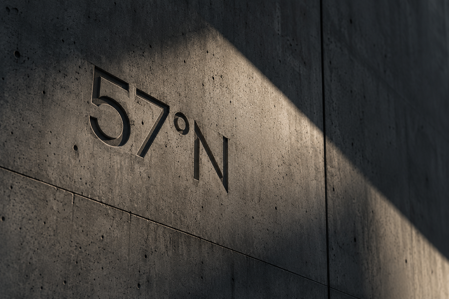 The 57°N wordmark recessed into a monumental board-formed concrete wall, lit by raking daylight.